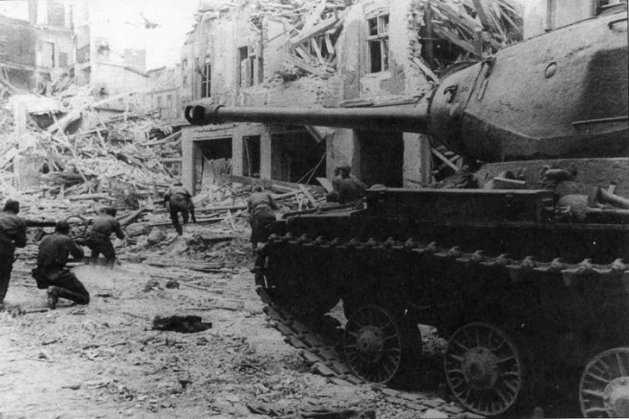 Танк ИС-2 Героя Советского Союза гвардии капитана Федора Липаткина поддерживает штурмовую группу пехоты в бою на берлинской улице
