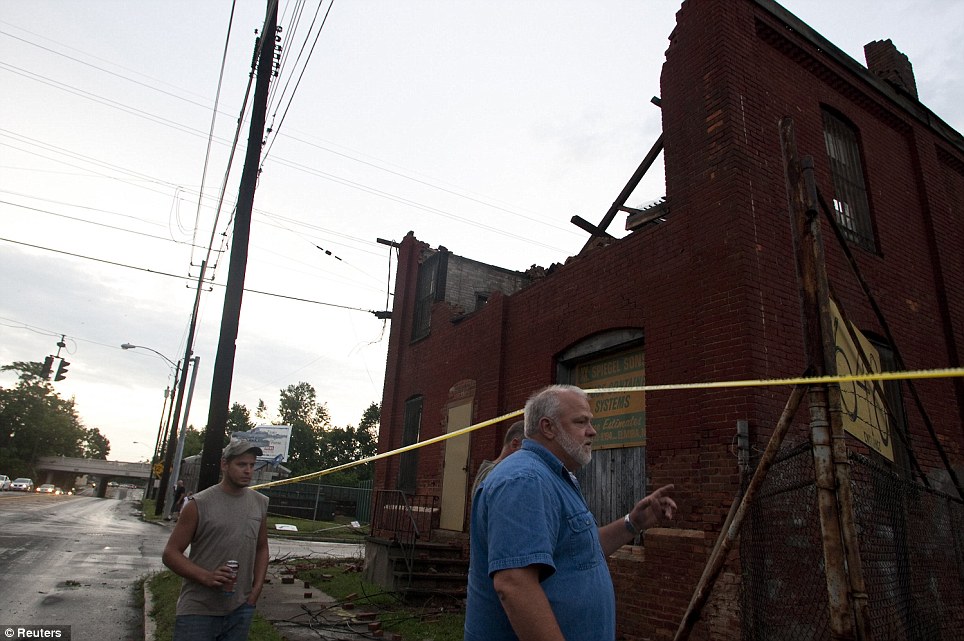 Path of destruction: Gary Dunning surveys the damage to his business after a tornado struck in Elmira, New York on Thursday