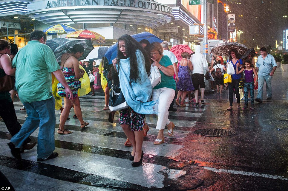 City slickers: Pedestrians rush through a torrential downpour in Times Square, Manhattan