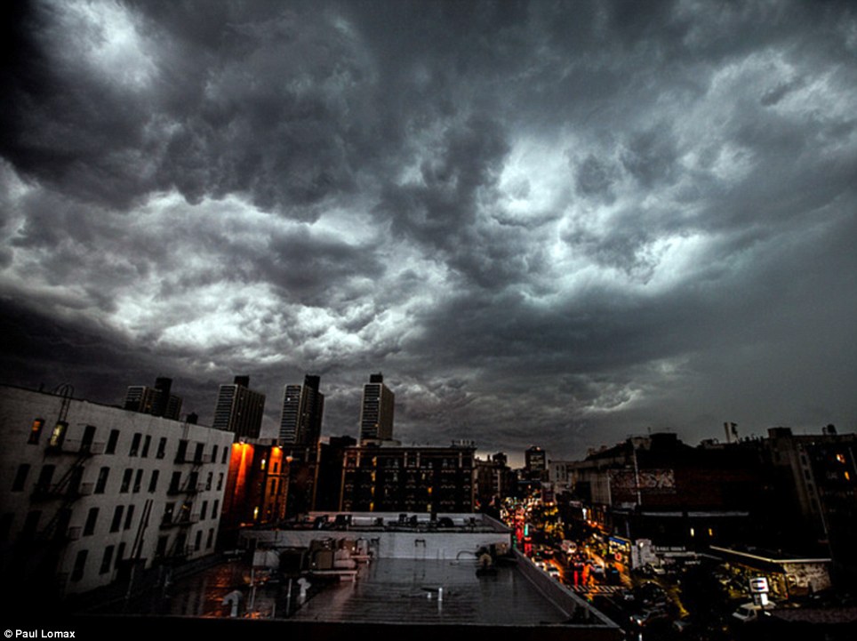 Unpredictable: Dark clouds loom over New York City as thunderstorms and torrential rain batter the U.S.