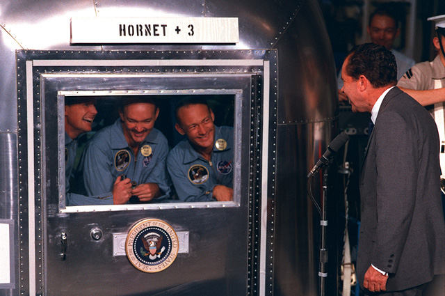 Президент Никсон общается с экипажем «Аполлона-11», находящимся в карантинном фургоне.