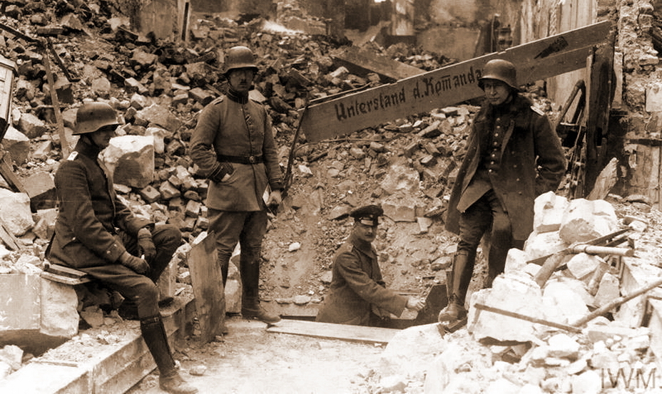 ​Немецкие офицеры возле укрытия в развалинах, используемого в качестве командного пункта. Снимок сделан в апреле 1917 года в Сен-Кантене, департамент Эна. Этот город был одним из укреплённых пунктов линии Гинденбурга и сильно пострадал в боях. http://www.iwm.org.uk - Бойня Нивеля 